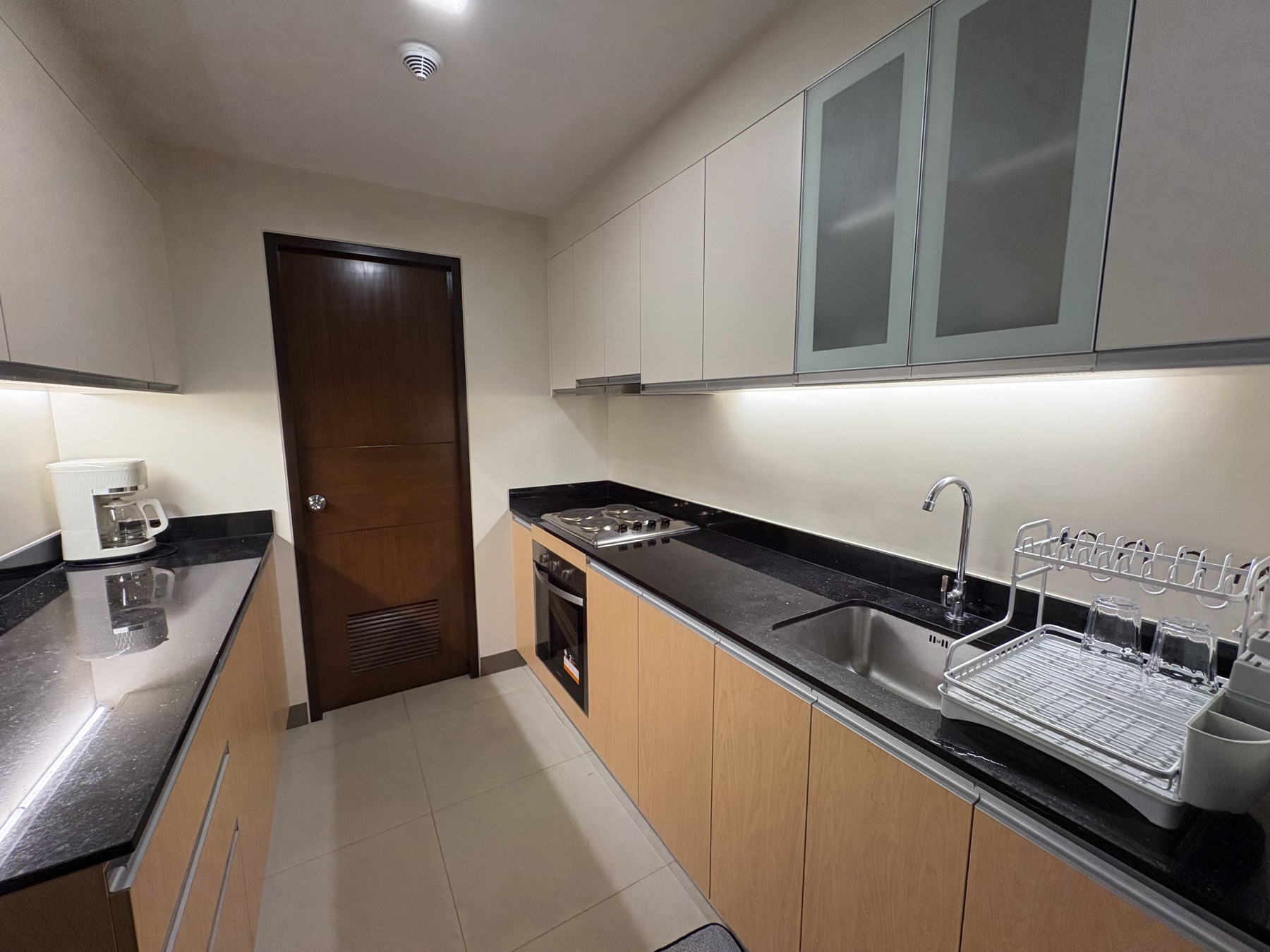 Galley kitchen in the DAYON TA condo, with a gas hob, oven, and counters running the length of both walls