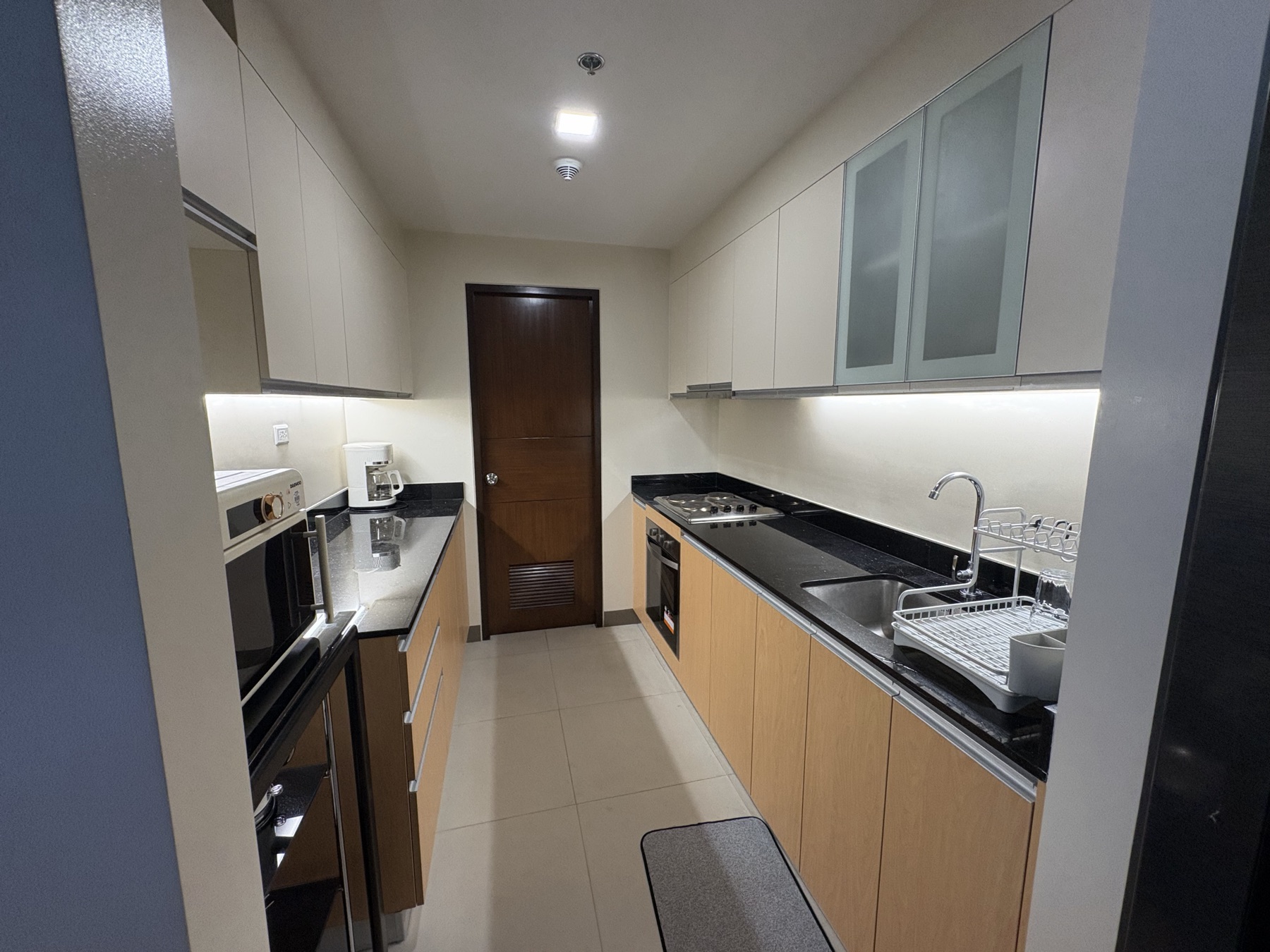 Second bedroom of the DAYON TA condo, with a bunk bed — a double below and a single above — a full-height wardrobe, and a balcony door onto the city
